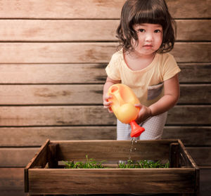 Close-up portrait of baby girls watering plants