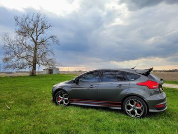 Car on field against sky