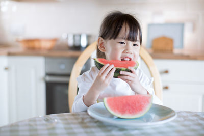 Cute girl eating watermelon at home