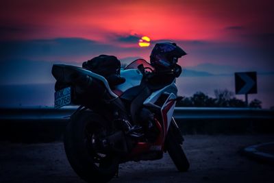 People on motorcycle against sky during sunset