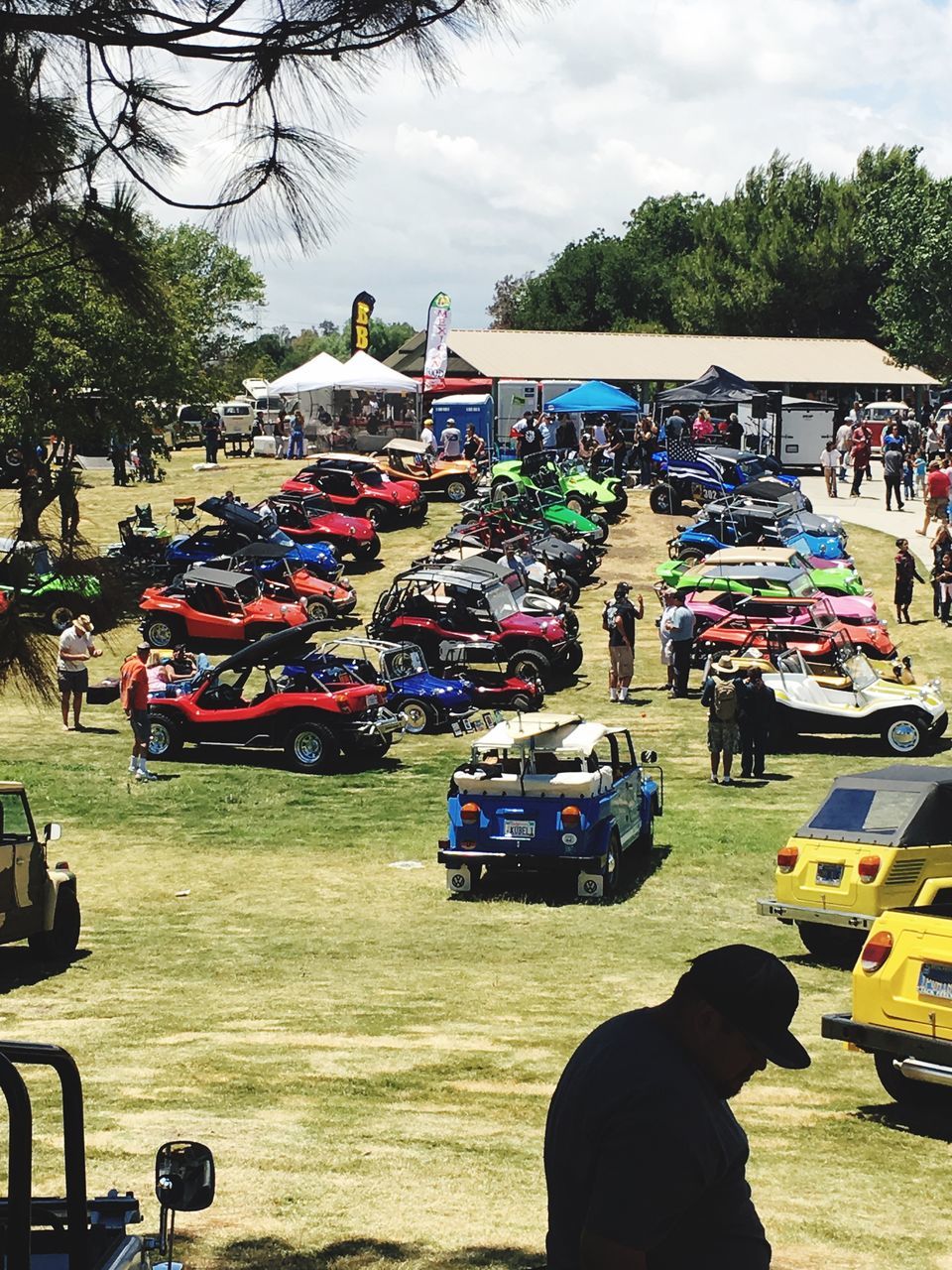 transportation, mode of transport, tree, land vehicle, car, real people, sky, incidental people, motorcycle, day, large group of people, cloud - sky, outdoors, men, bicycle, lifestyles, stationary, women, people in the background, nature, water, people