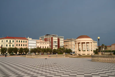 Buildings in city against clear blue sky