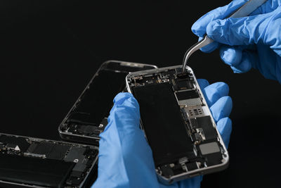 Technician repairing the smartphone's motherboard in the lab with copy space.