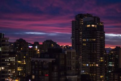 Illuminated buildings against sky at sunset
