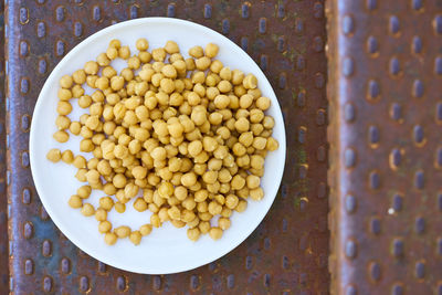 Directly above view of fresh chickpeas in plate on sheet metal