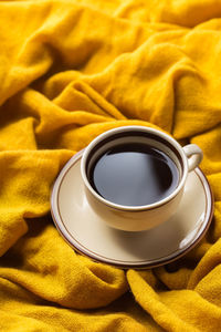 High angle view of coffee cup on bed