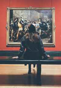 Rear view of woman looking at camera in museum