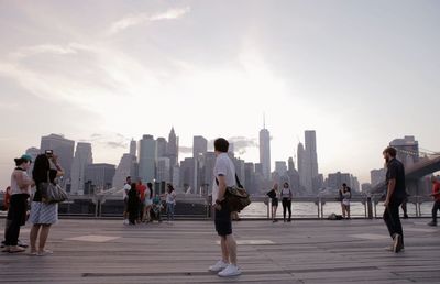 People walking in city against sky