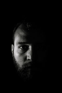 Portrait of young man against black background