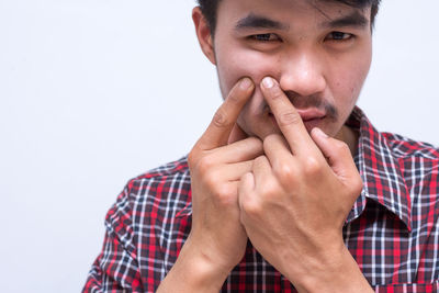 Close-up portrait of young man against white background