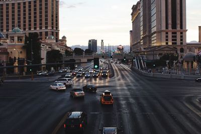 Cars on city street by buildings