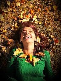 Portrait of smiling young woman with leaves during autumn