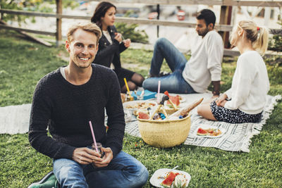 Portrait of happy man having rooftop party with friends