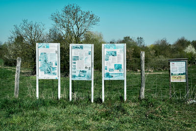 Information sign on field against clear sky