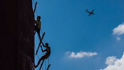 Low angle view of silhouette tree against blue sky
