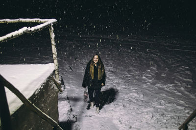 Portrait of woman on snow covered land