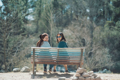 Women friends sitting together in a bench