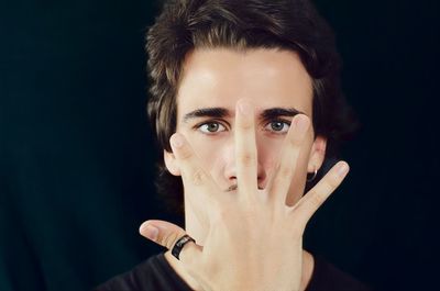 Portrait of young man against black background