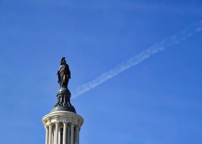 Low angle view of statue against blue sky