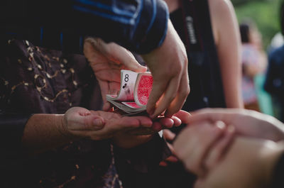Close-up of man shuffling cards on people hands