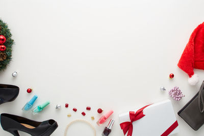 Directly above shot of beauty products and christmas decorations on white background