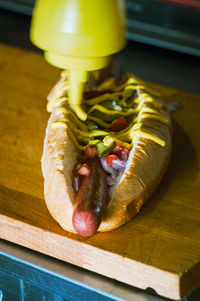 Close-up of food on cutting board, hotdog in making.