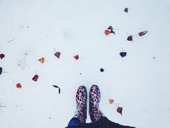 Low section of woman standing on snow field