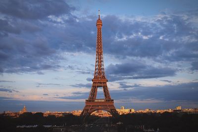 Low angle view of eiffel tower against cloudy sky during sunset