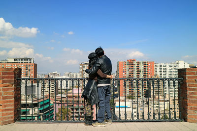 Man standing by building against sky in city