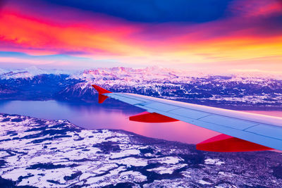 Aerial view of snowcapped mountains against sky during sunset