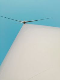 Low angle view of wind turbine against clear blue sky