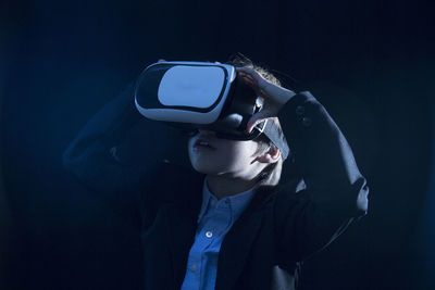 Boy wearing suit while using virtual reality simulator