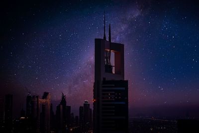 Low angle view of illuminated buildings against sky at night