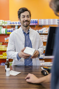 Pharmacist explaining medicine to customer in pharmacy