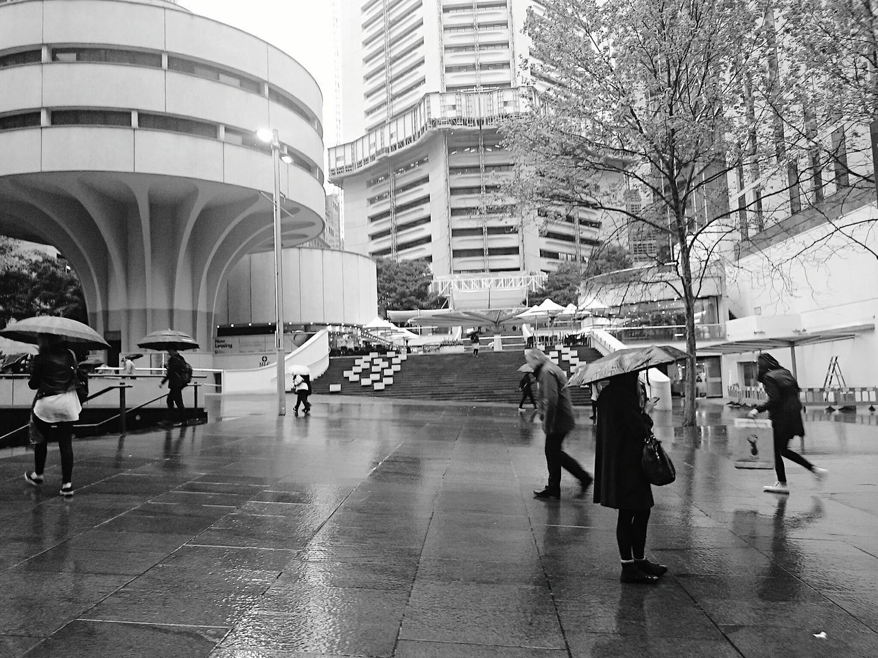 building exterior, architecture, lifestyles, built structure, person, men, walking, leisure activity, full length, large group of people, city, city life, street, casual clothing, building, umbrella, water, day, tree