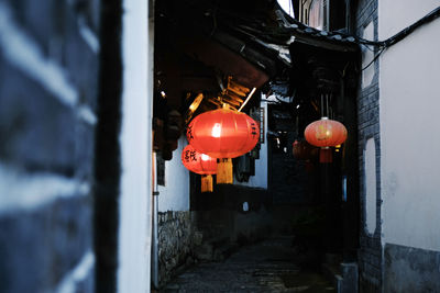 Illuminated lanterns hanging by building