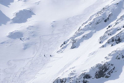 Ski alpinists in snowy alpine terrain climbing uphill , slovakia, europe