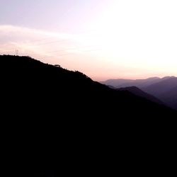 Scenic view of silhouette mountain against sky at sunset