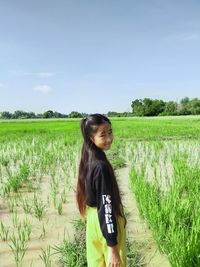 Woman standing on field against sky