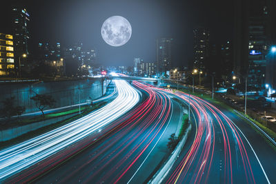 Light trails on road against sky at night