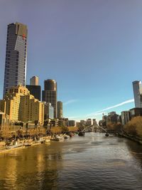River amidst buildings in city against clear sky