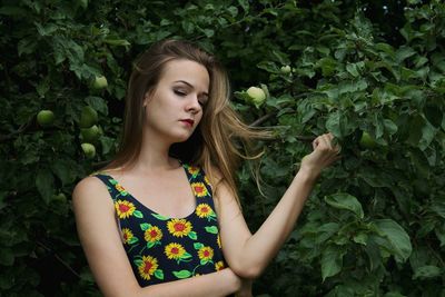 Beautiful young woman against plants
