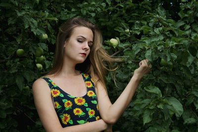 Close-up of woman with closed eyes standing by guava tree