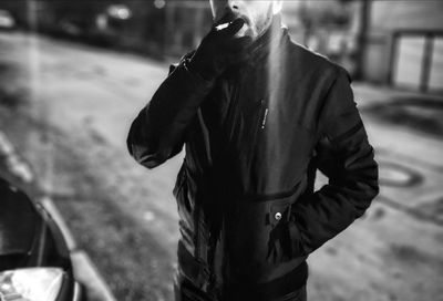 Midsection of man standing on street in city