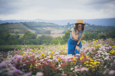 Beautiful woman standing in blooming flower garden