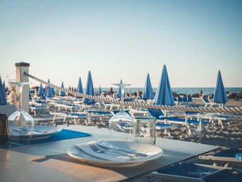 Boats moored in swimming pool against clear blue sky