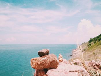 Rocks on sea shore against sky