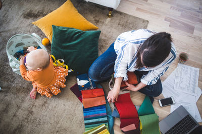 High angle view of girl sitting with toy at home