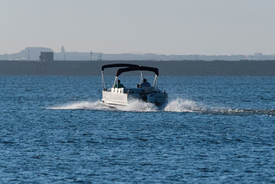 Power boat heading out across a lake leaving a wake behind.