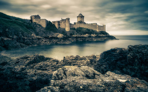 Scenic view of sea by buildings against sky